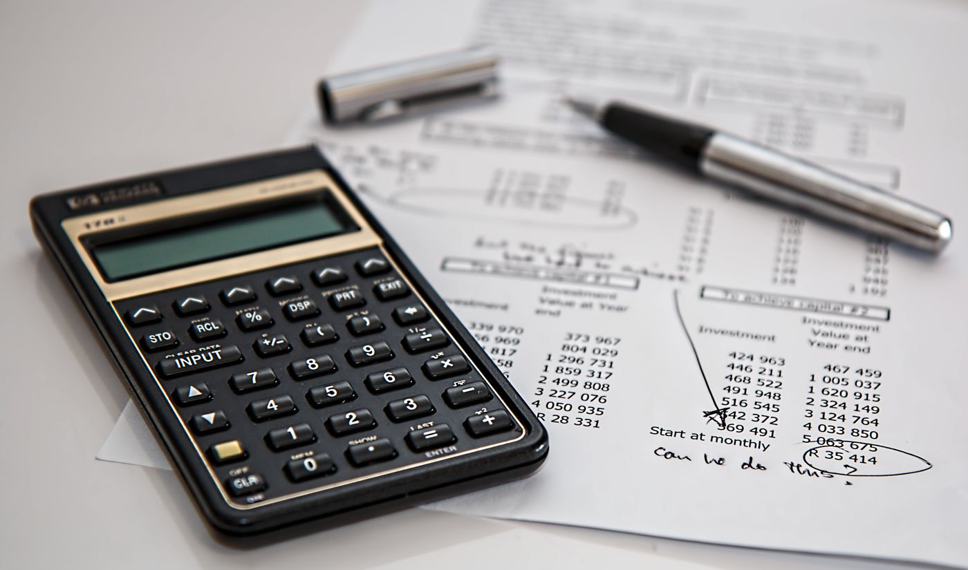 Calculator and financial documents used to represent margin analysis